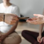 A serene group engaging in meditation with hands passing beads, promoting tranquility and mindfulness.