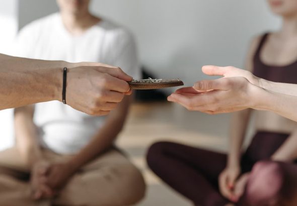 A serene group engaging in meditation with hands passing beads, promoting tranquility and mindfulness.